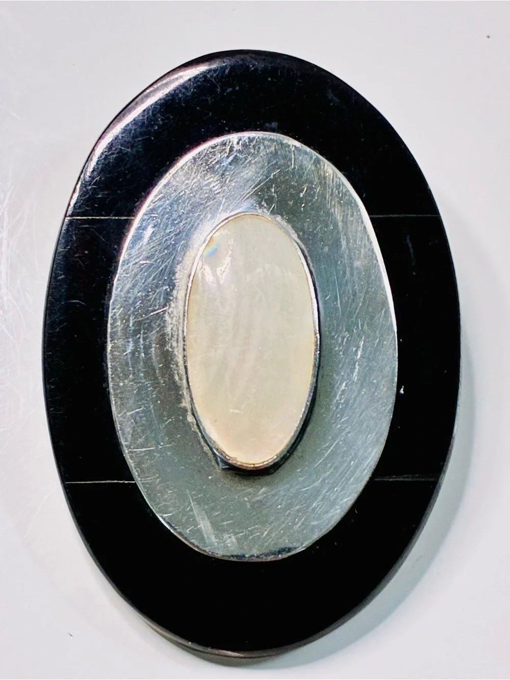 Elevated Simple Black and Silver Oval Brooch with Mother-of-Pearl Center Pendant
